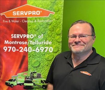 employee in black servpro shirt and glasses