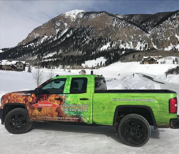 A SERVPRO truck in front of snowy mountains.