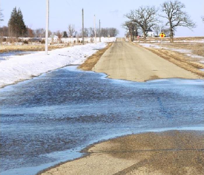 snow melting on side of road; water on road