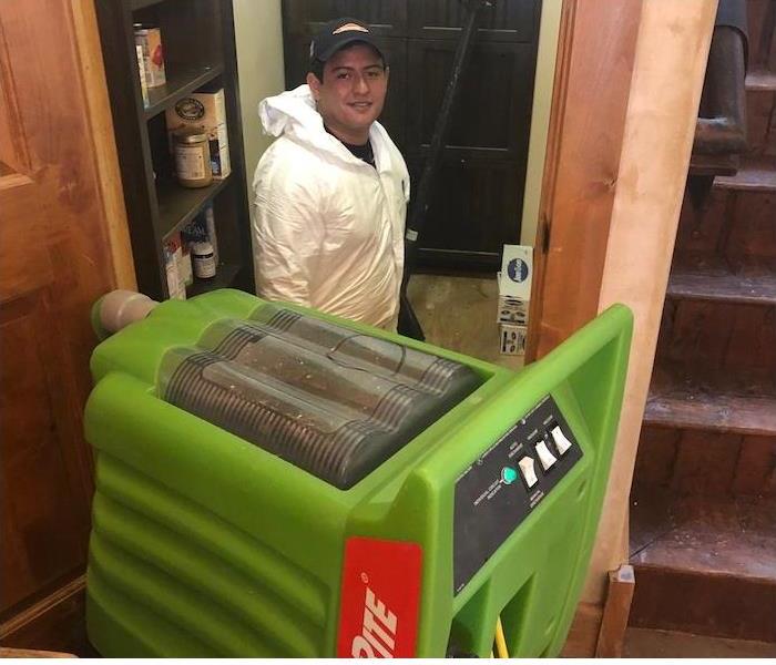 SERVPRO employee with a water extraction machine