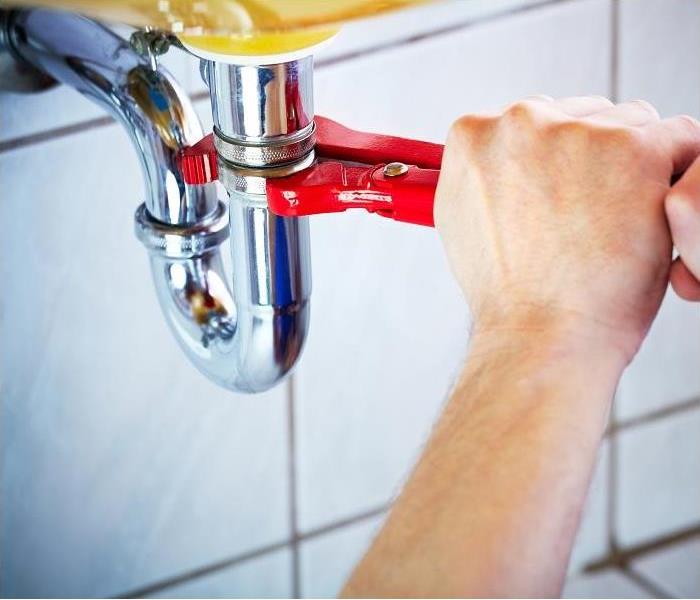 plumber tightening drainpipe